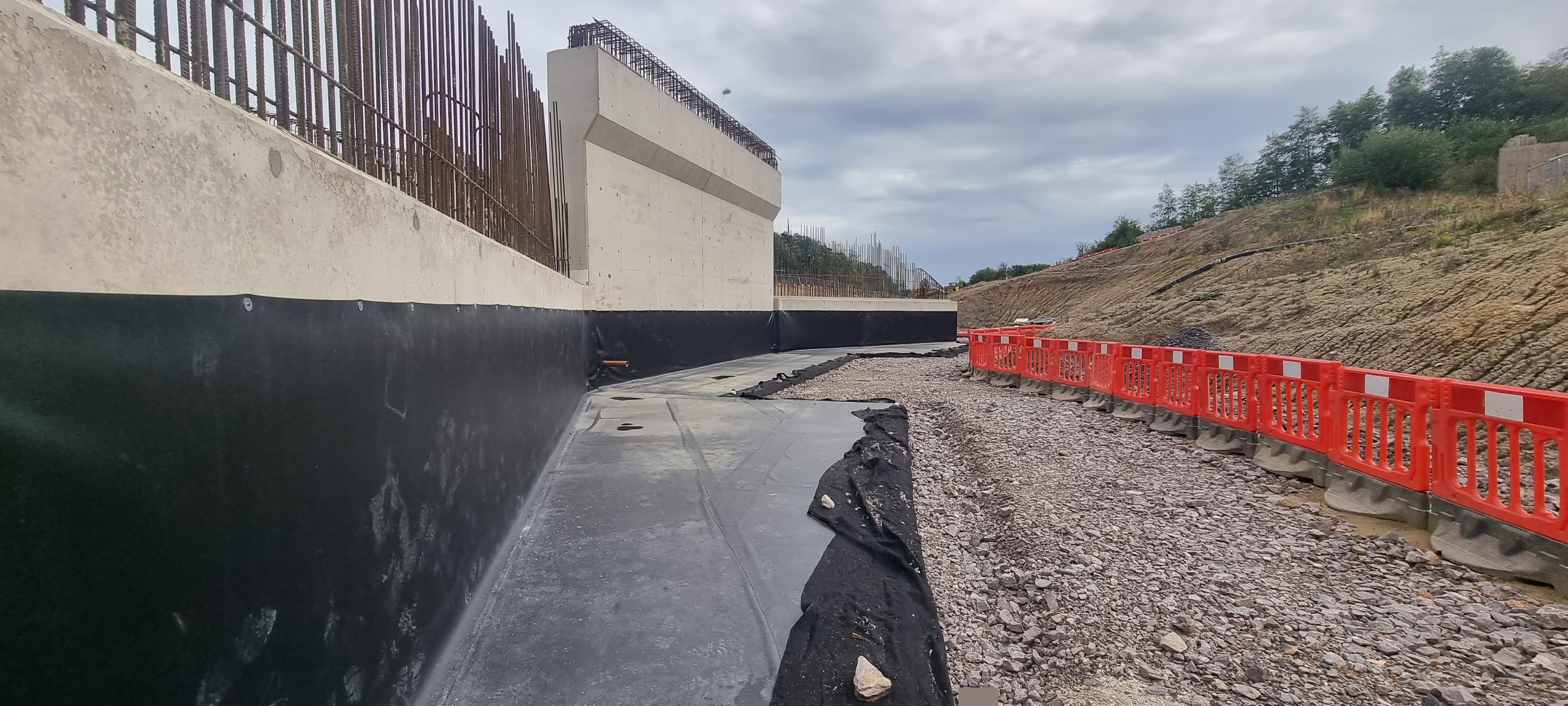 Underpass retaining wall with waterproofing
